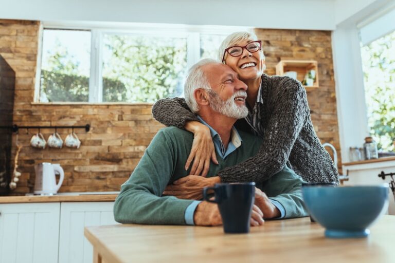 Happy Couple Sitting By Coffee Table