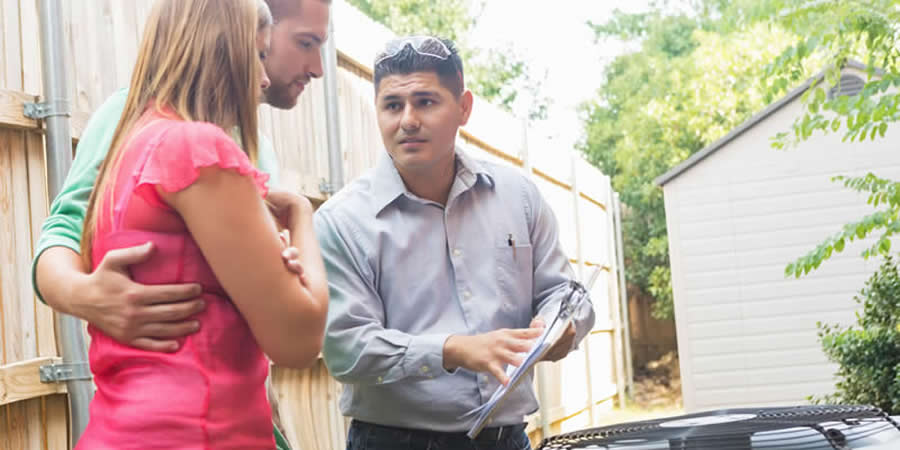 hvac-dealer-talking-with-homeowners-about-ac-unit