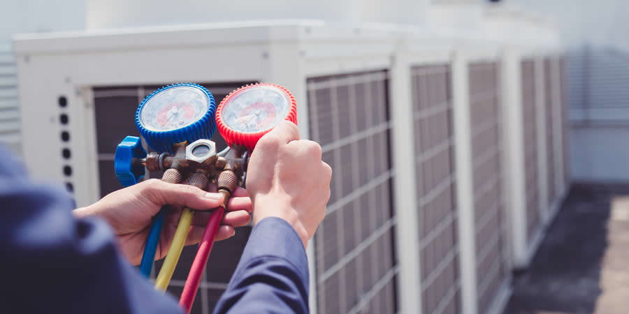 hvac-tech-checking-pressure-on-commercial-unit